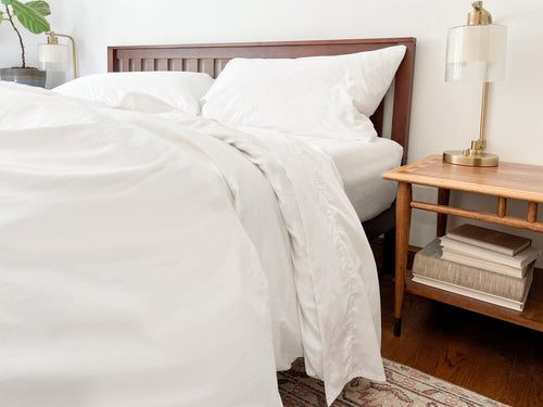 Crisp GOTS-certified organic cotton percale sheet set on a made bed
